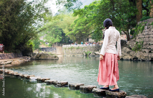 Girl walking on the stone bridge in the river © creativefamily