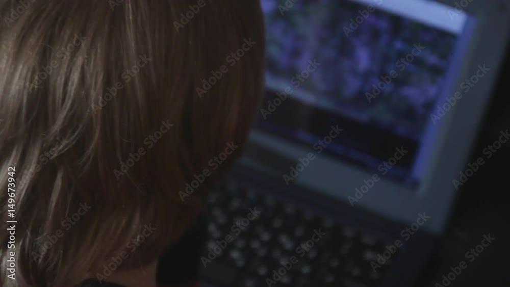 Close up of a little boy sitting on the floor and trying to learn with a computer. New generation and technology concept.