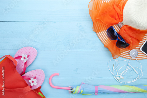 Beach accessory,sunglasses, beach hat,flip-flops,umbrella, compass,music player,earphone on wooden background,concept summer holiday background.