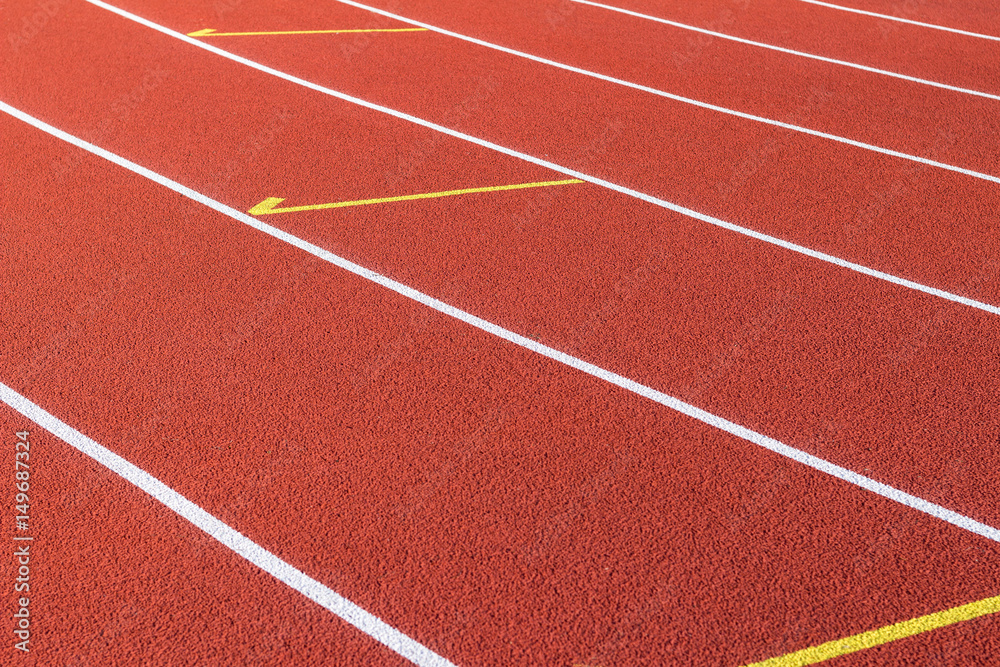 Red running track and white lanes on sport stadium