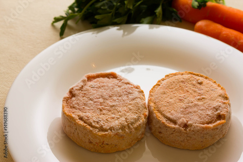 Frozen carrot patties on a white plate and ingredients. The concept of a healthy diet. Vegetarian cuisine.