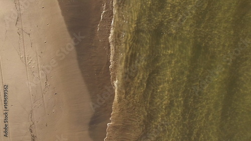 Aerial view of Baltic sea shore, waves and sandy beach.