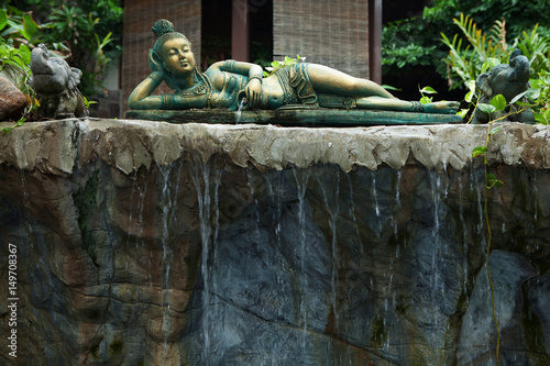 fragment like view of laying girl statue in tropic spa environment photo