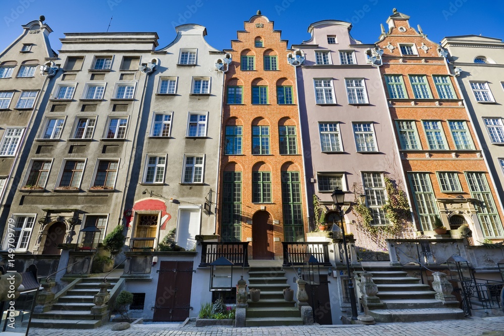 Obraz premium Burgher houses with entrance terraces and richly decorated facades on the Mariacka Street - one of the most beautiful streets of the Old Town of Gdańsk, Poland at sunrise