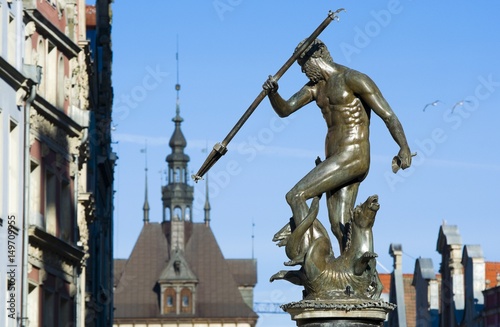 Neptune Fountain - symbol of Gdansk, located at Long Market, blurred roof of the Prison Tower in the background, Poland