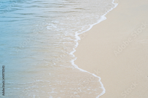 Soft wave of blue ocean on sandy beach. Background.