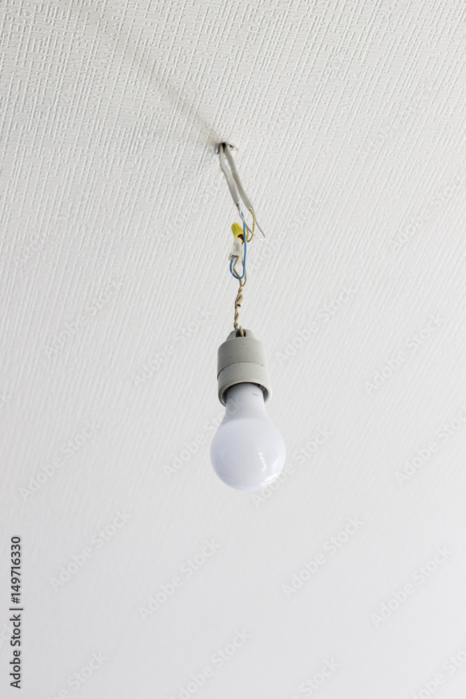 white bulb hanging from the white ceiling on wires white bulb hanging from the white ceiling on wires