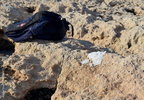 tourist backpack dry sea salt on the rocky background