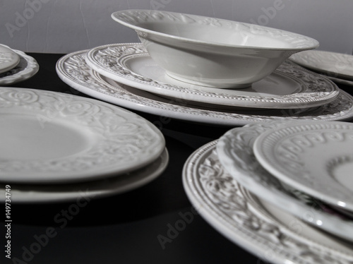 Set of white ceramic relief plates on background