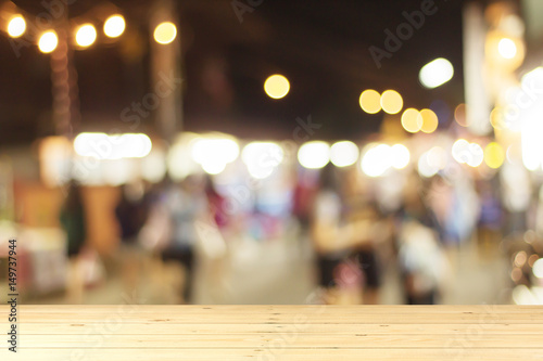 Wooden tabletop with blurred people shopping background