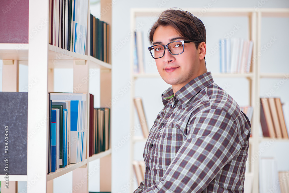Fototapeta premium Young student looking for books in college library
