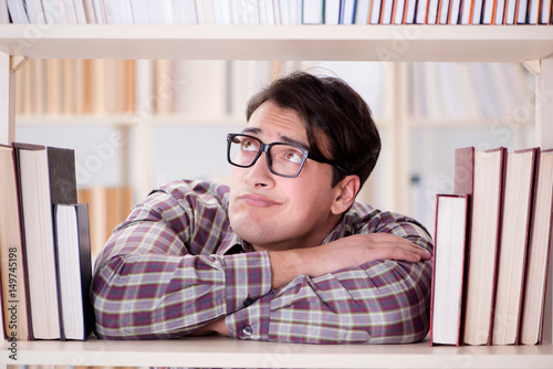 Young student looking for books in college library