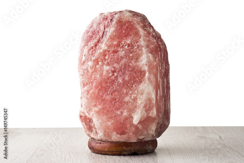 Pink salt lamp isolated on wood table photo