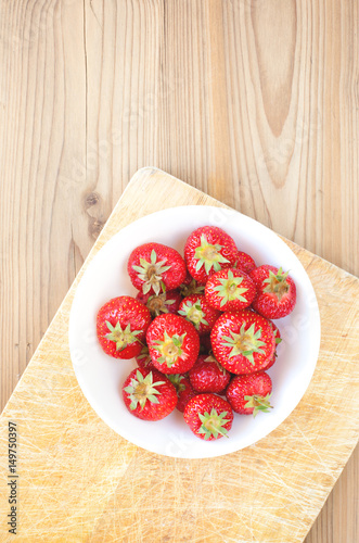 Strawberries white bowl on wooden table