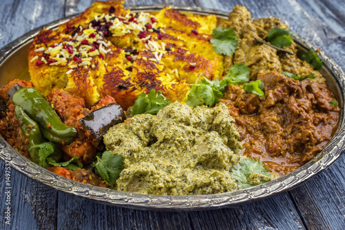 Traditional Indian Iranian Curries with Tahdig as close-up on a Thali photo