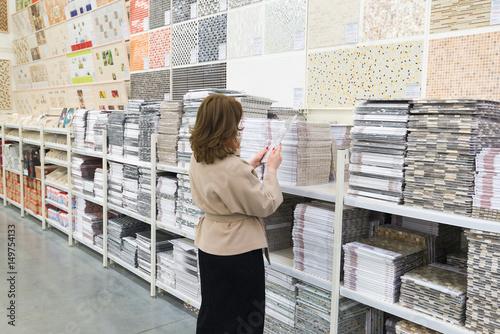 woman chooses a ceramic tile in a store