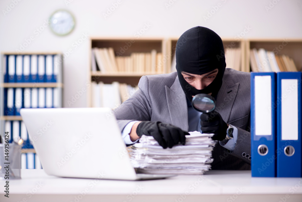 Criminal businessman wearing balaclava in office Criminal businessman wearing balaclava in office