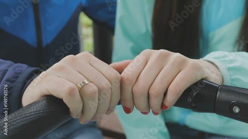 A married couple walks in a park with a stroller and talks