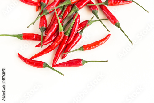 red hot chili peppers, popular spices and cooking spicy food concept - heap of scattered hot red peppers half-filled white background, flat lay, empty space for the text