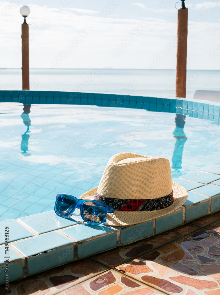 Obraz premium Image of hat and sunglasses by pool