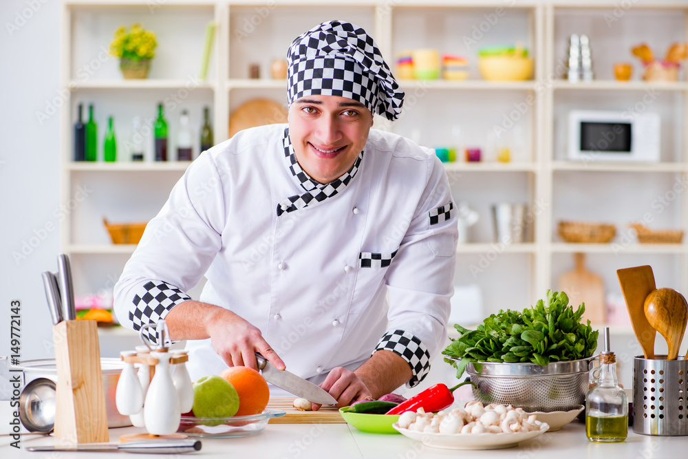 Young male cook working in the kitchen Young male cook working in the kitchen