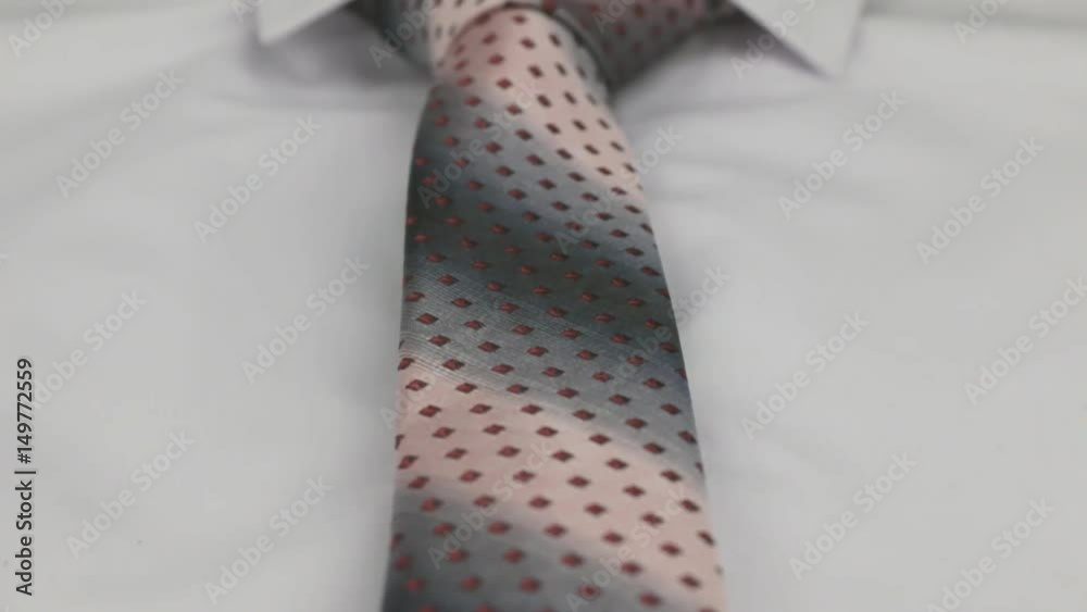 Red tie on a white shirt, close-up. Dolly shot.