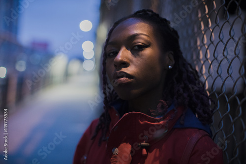 Urban portrait of a young, black woman in the streets of New York City. The model poses on the city's Manhattan Bridge.