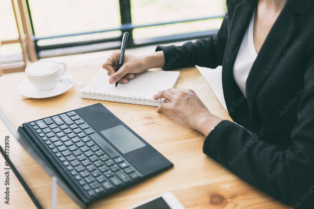 Business woman working on desk with laptop computer,Business woman using pen for note to do list concept.