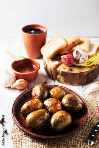 Wallpaper Mural Russian and Ukrainian national cuisine, potatoes in their skin with fish, white bread, onions, garlic, cucumber and vegetable oil on a light wooden background  Torontodigital.ca