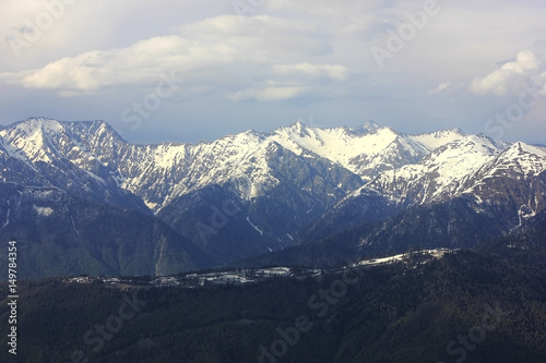 Mountain landscape. Mountain chain with snowy peaks. Mountain valley in cloudy weather. Sochi, Russia.