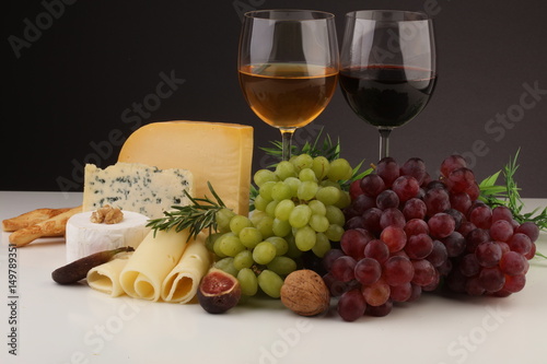Cheese platter with different cheese and grapes and red wine