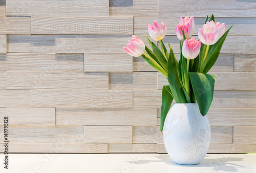 Beautiful bouquet of fresh tulips flowers against brick wall background