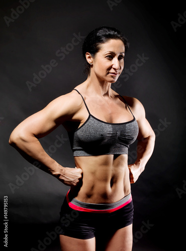 Muscular bodybuilder woman showing her muscles.