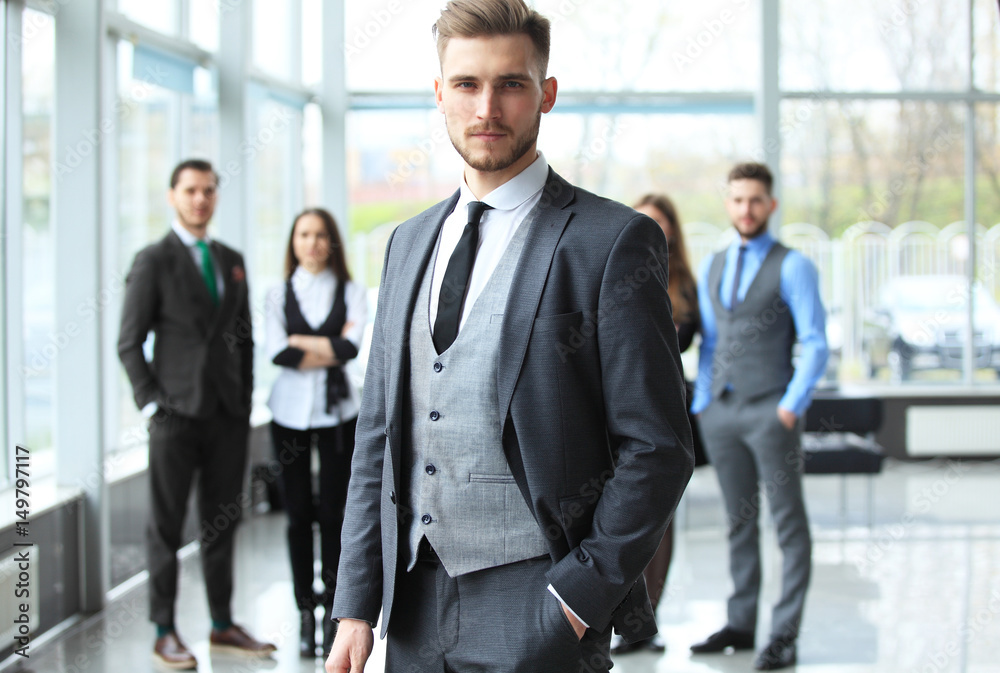 Happy smart business man with team mates discussing in the background. Happy smart business man with team mates discussing in the background.