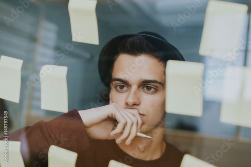 young entrepreneur freelance organizing work with notes on the glass or panel