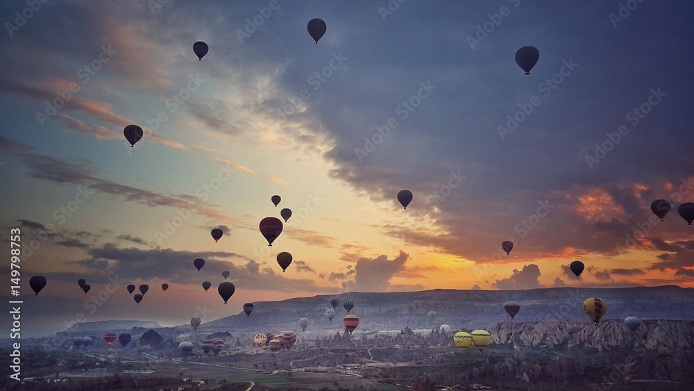 Colorful hot air balloons flying over the valley at Cappadocia, Turkey. Beautiful Sunrise.