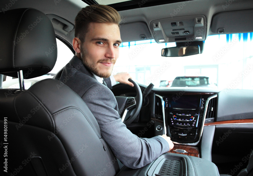 Portrait of an handsome guy driving his car.