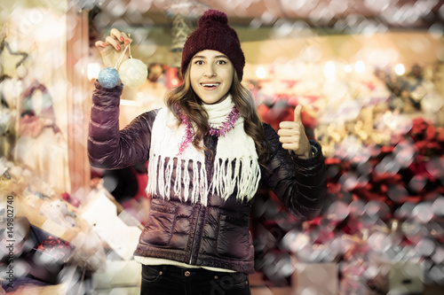 Woman choosing Christmas decoration at market