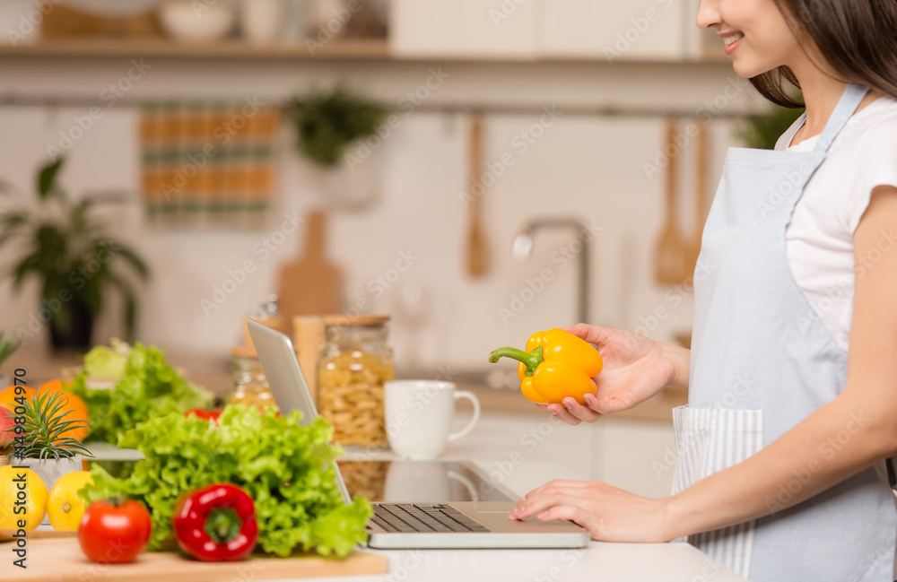 Young Woman standing in kitchen with tablet computer and looking recipes. Close-up. Young Woman standing in kitchen with tablet computer and looking recipes. Close-up.