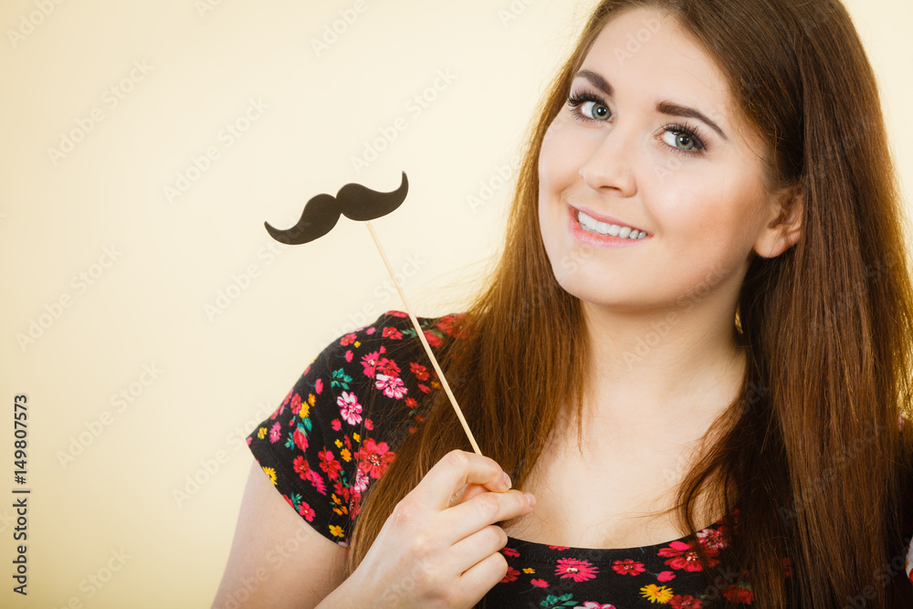 Happy woman holding fake moustache on stick Happy woman holding fake moustache on stick