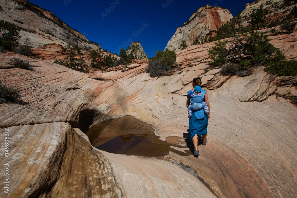 A woman with her baby boy are trekking in Zion national park, Utah, USA A woman with her baby boy are trekking in Zion national park, Utah, USA