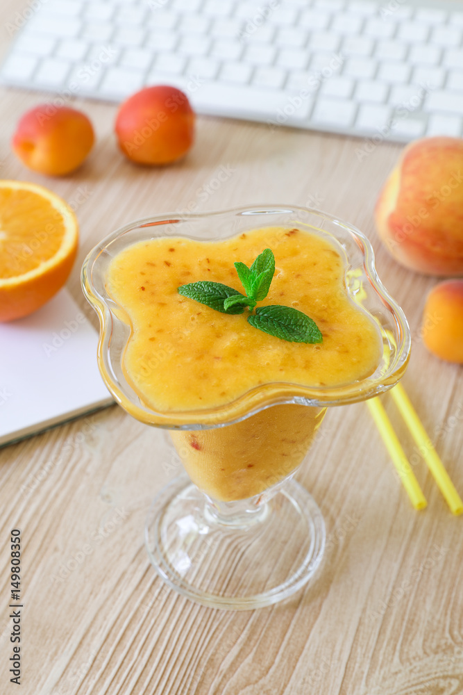 Healthy drink fruit smoothie of peach, apricot, orange in the workplace. Healthy drink fruit smoothie of peach, apricot, orange in the workplace.