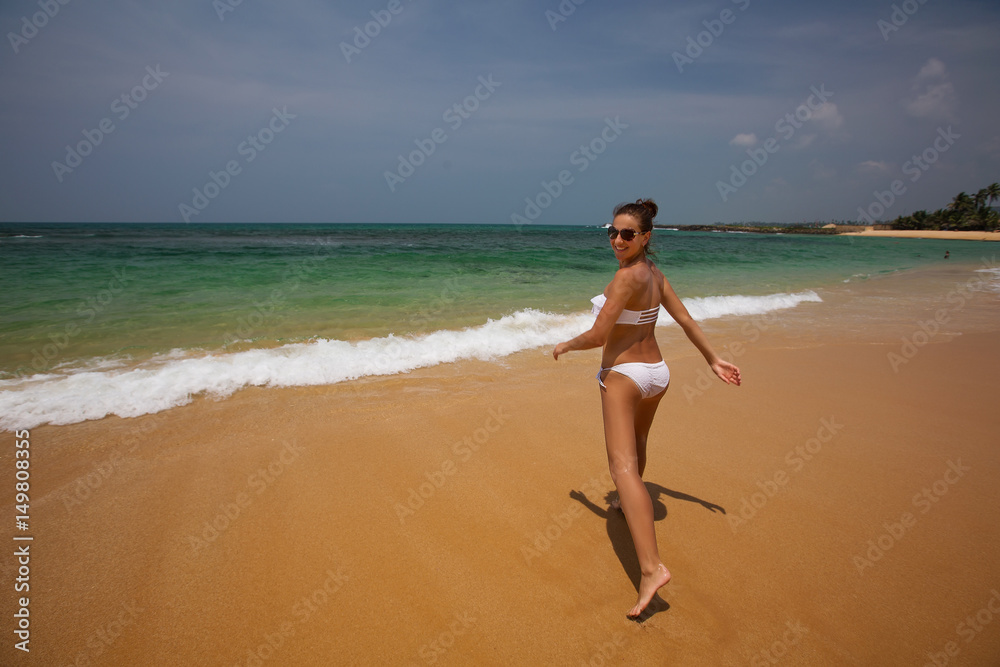 A woman in white bikini is having fun at the seashore A woman in white bikini is having fun at the seashore