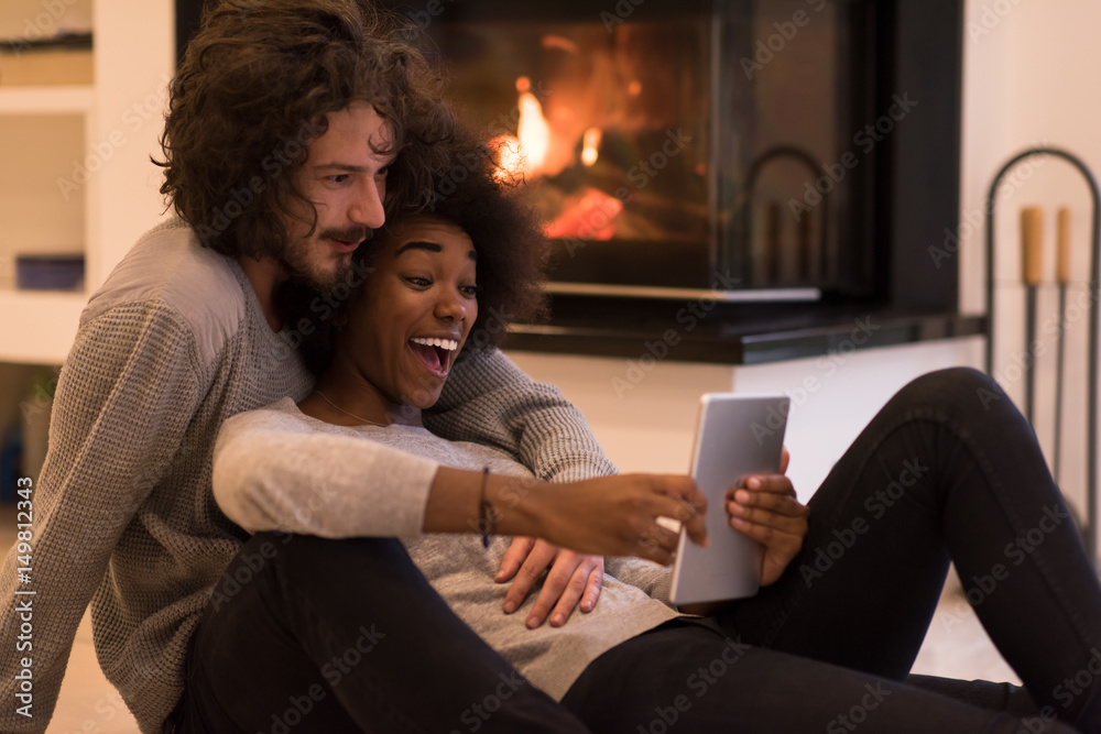 multiethnic couple using tablet computer on the floor multiethnic couple using tablet computer on the floor
