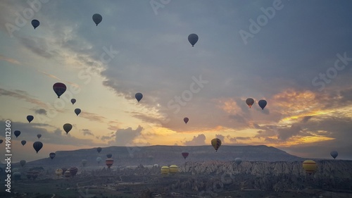 Sunrise over the valley in Cappadocia, Turkey. Hot air balloons flying over field.