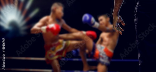 Boxing Referee and blurry of child boxer,Muay Thai.Real shot with night scene.