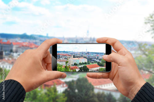 Man taking photo with smartphone of city skyline