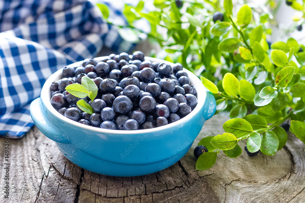 Fresh blueberries with leaves on wooden background Fresh blueberries with leaves on wooden background