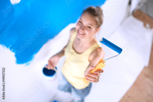 Beautiful young woman doing wall painting   standing