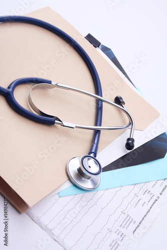 Afile folder, a stethoscope and a pen on ekg photo